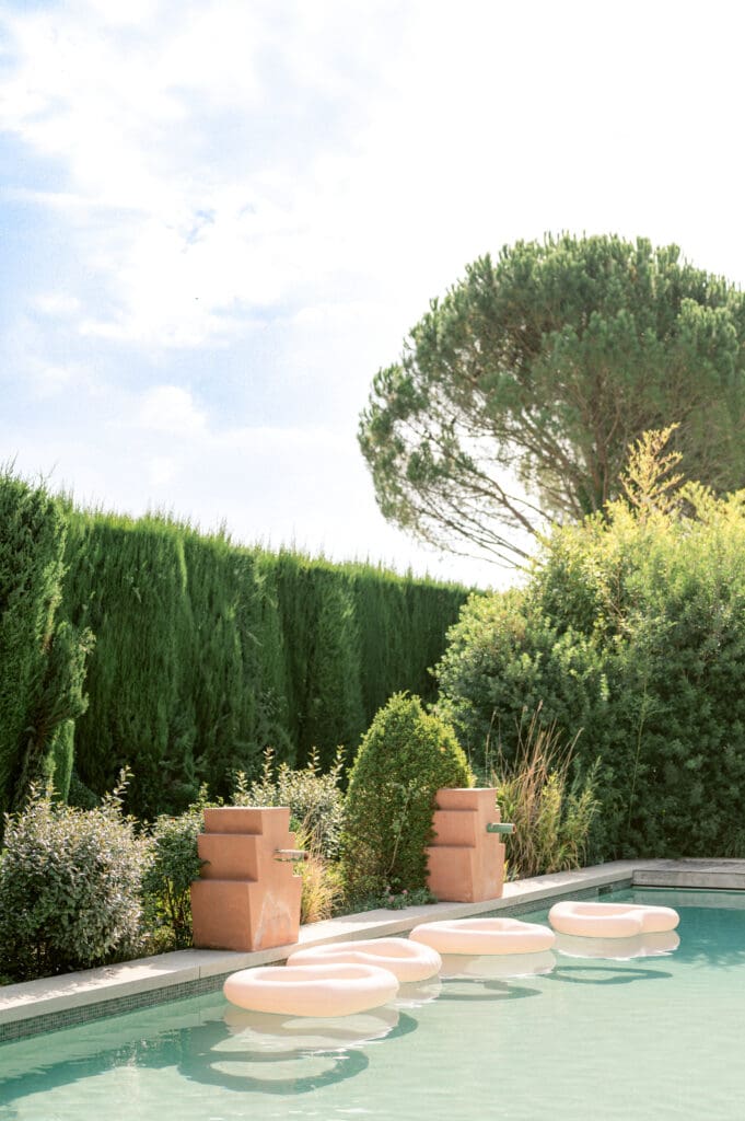 Bride relaxing poolside in the sunlight, showcasing fashion-forward style and editorial elegance in a Provence wedding setting.