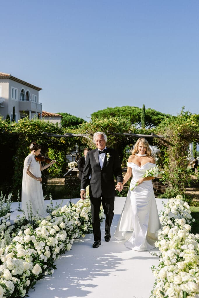 Bride walking down the floral aisle during luxury wedding ceremony in Saint-Tropez.