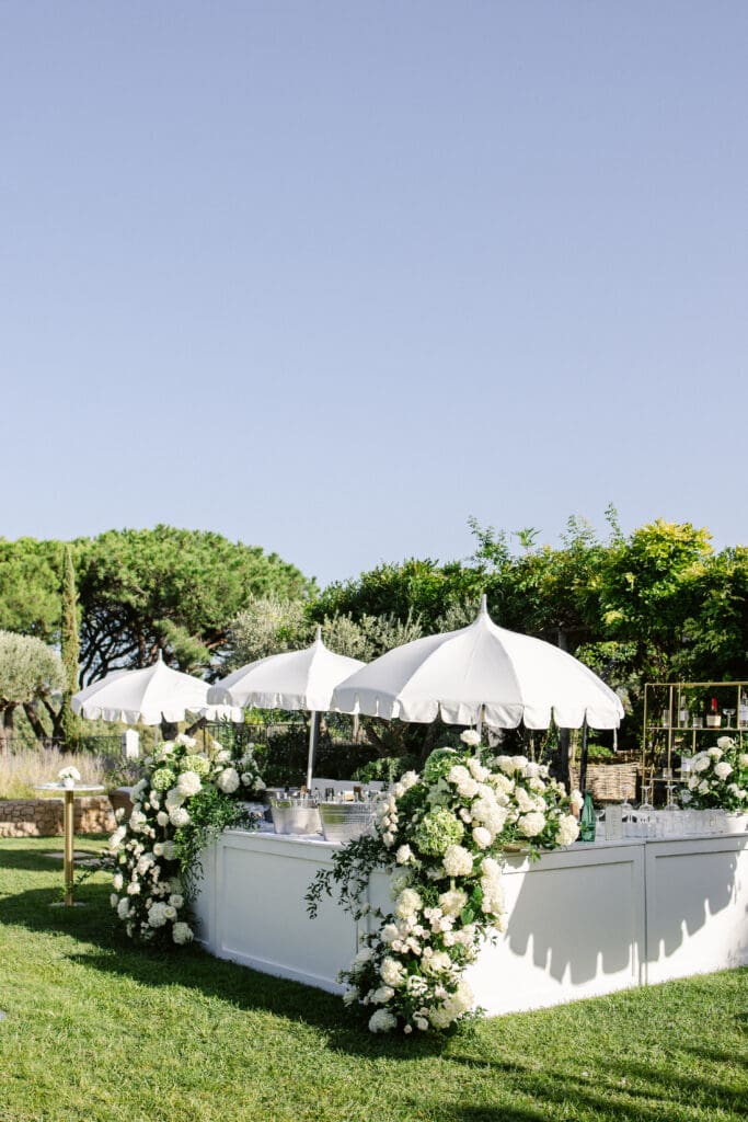 Elegant outdoor bar with white flowers during high-end destination wedding in France.