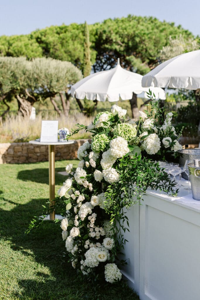 White floral design on outdoor bar at destination wedding cocktail in French Riviera.