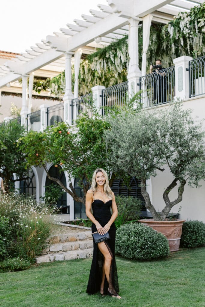 Chic guest in black dress during luxury destination wedding cocktail at Airelles Saint-Tropez.