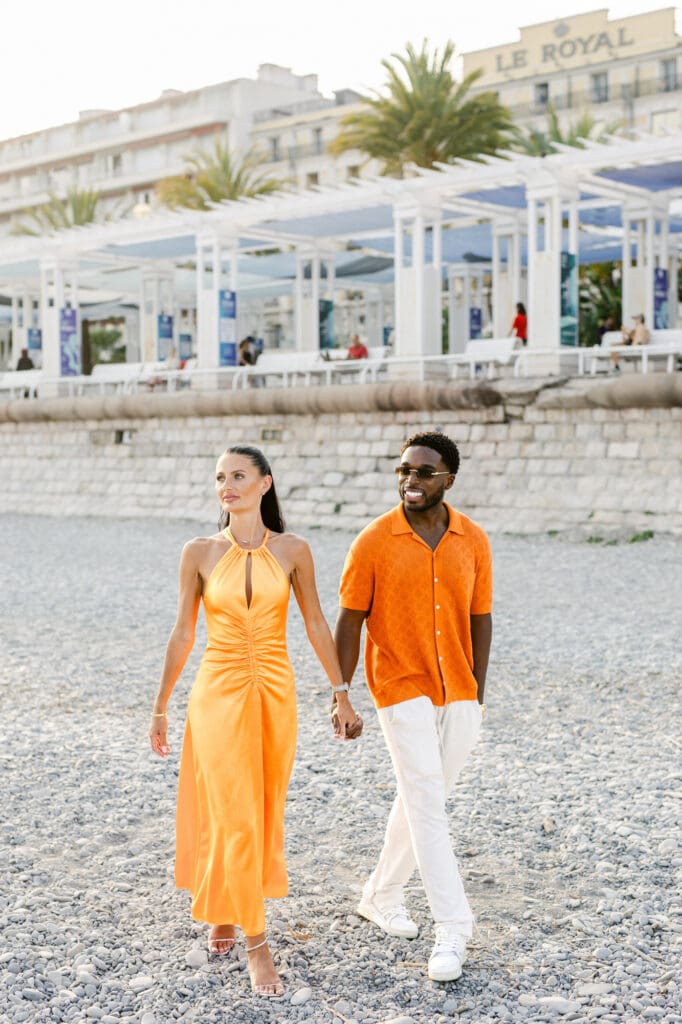 Bride and groom in orange at welcome dinner Boccamar Nice surrounded by guests in white — Marion Pinel